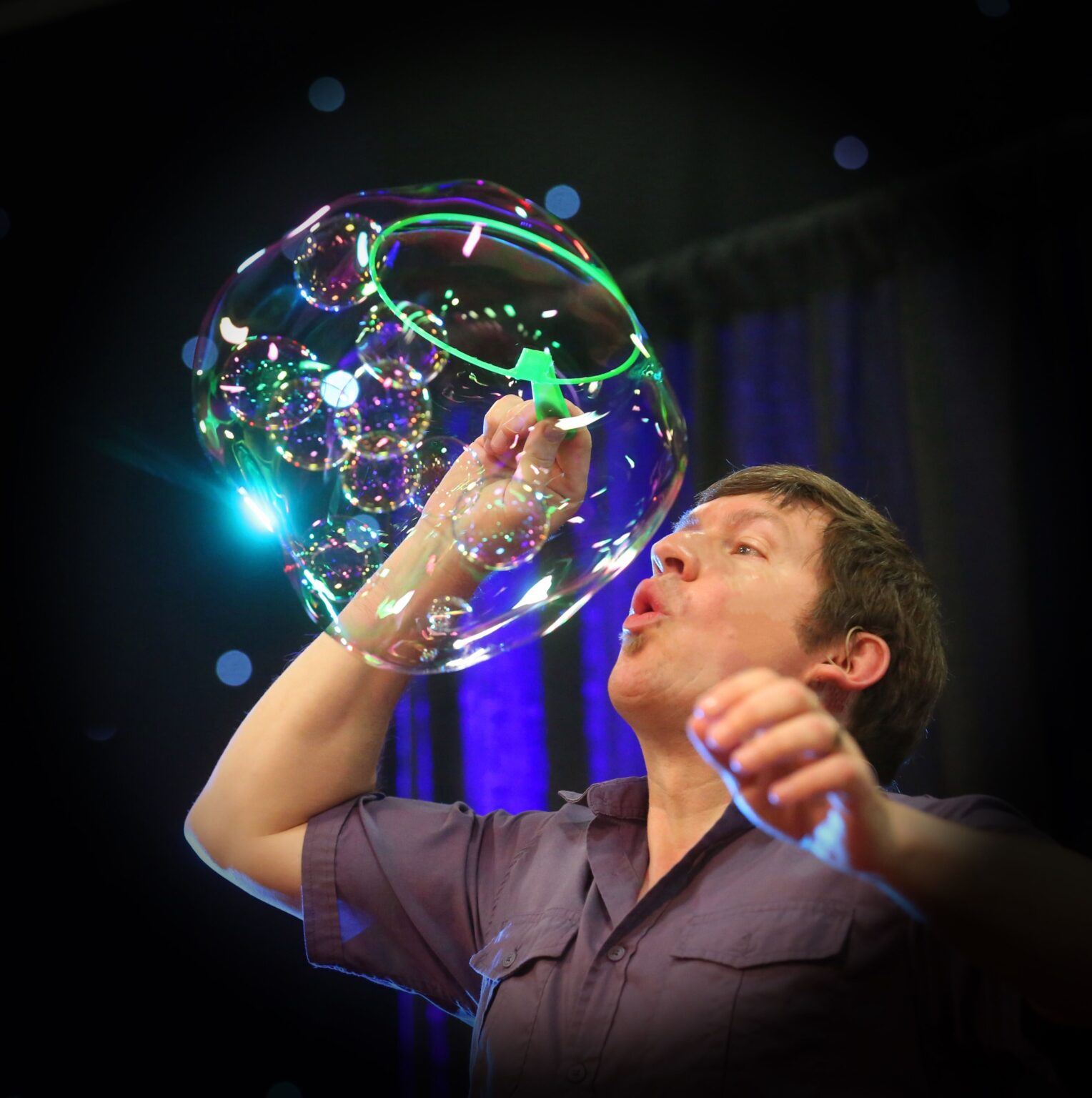 man blowing a giant bubble 